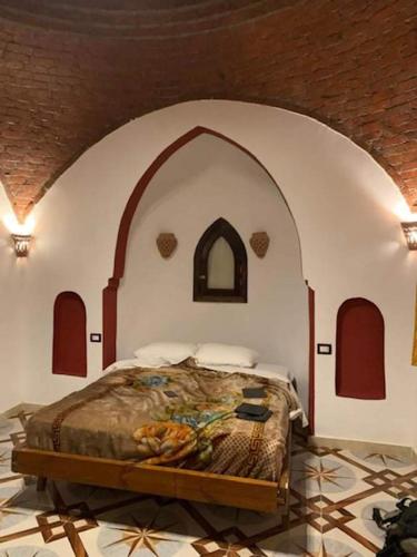 a bed in a room with a wooden floor, Nubian Eco Village in Luxor