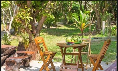 a wooden table topped with chairs next to plants, Baan Loylom Farmstay in Amphawa (Samut Songkhram)