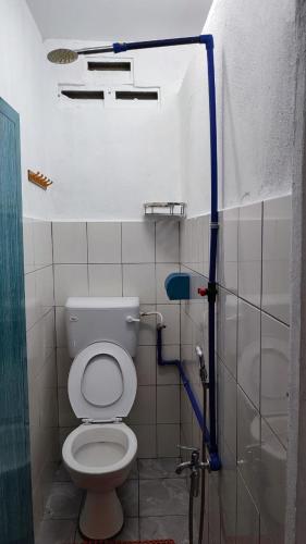 a bathroom with a toilet, sink, and shower stall, Taun Gusi Village Homestay in Kota Belud