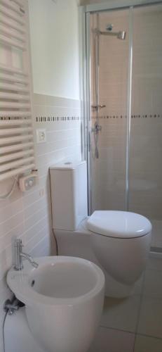 a white toilet sitting next to a bath tub in a bathroom, La Terrazza di Peun in Riomaggiore