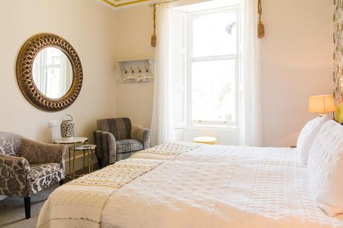 a bedroom with a bed and a mirror, The Merryburn - Rooms and Courtyard Studios in Dunkeld