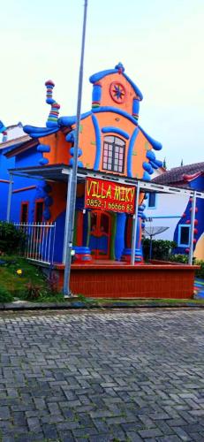 a building with a clock on the side of it, Villa Miky At Kota Bunga Puncak in Puncak