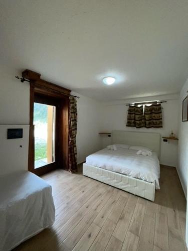 a bedroom with a bed and a window, Rifugio Baita Belvedere in Ayas