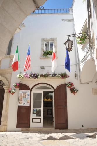 a building with a flag on the front of it, Villaggio In Case Sparse Nel Centro Storico in Martina Franca