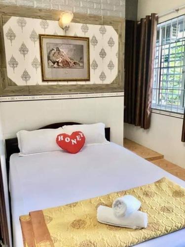 a bed in a room with a painting on the wall, Khanh Van - VT Cloud motel in Vung Tau
