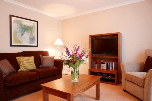 a living room filled with furniture and a tv, The Knight Residence by Mansley Serviced Apartments in Edinburgh