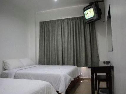 a hotel room with a television and a bed, Dynasty Inn Wakaf Che Yeh in Kota Bharu