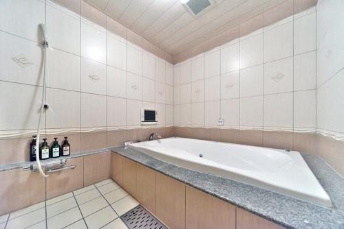 a bath room with a tub and a sink, Hotel Square in Gotemba