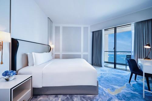 Suite Junior con cama extragrande, vistas parciales al mar y acceso al club