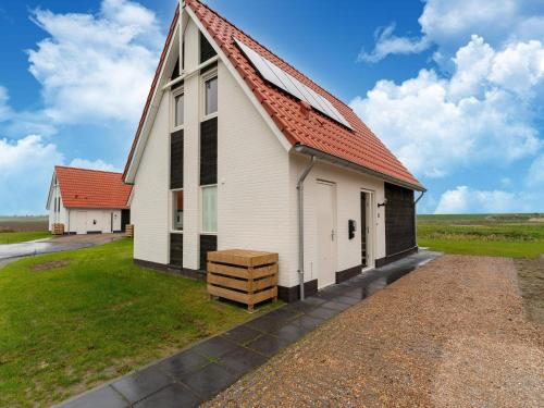 Vista exterior, Modern vacation home by the sea with covered terrace and sauna in Tholen