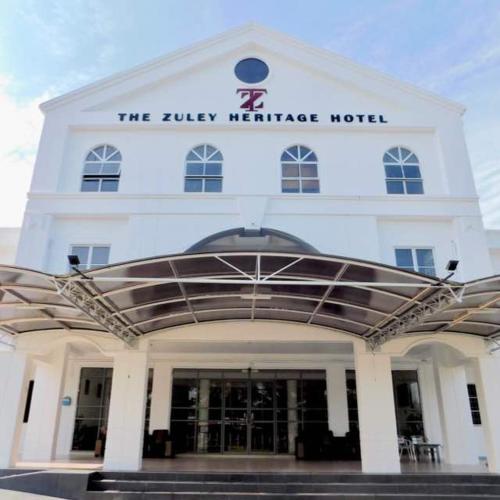 a large white building with a clock on the front of it, The Zuley Heritage Hotel in Kangar