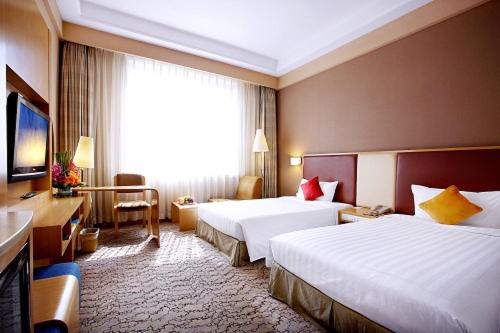 a hotel room with two beds and a television, Beijing XinQiao Hotel in Beijing