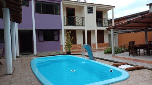 Casa roxa com piscina em condomínio