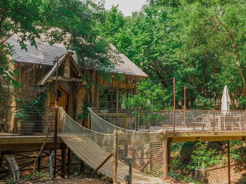 Hobbit Treehouse with waterfall on the Brazos River! 350 acres! Tubing! Petting zoo! image