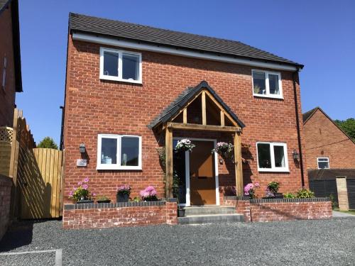 Luxurious 3 bedroom house Shangri la in village of Alfrick with free off road parking for 3 cars in an area of outstanding natural beauty, superb walking,close to Worcester, Malvern showground, theatre, Malvern hills, dogs welcome