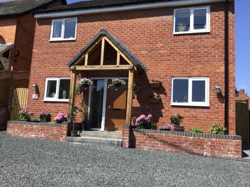 Luxurious 3 bedroom house Shangri la in village of Alfrick with free off road parking for 3 cars in an area of outstanding natural beauty, superb walking,close to Worcester, Malvern showground, theatre, Malvern hills, dogs welcome