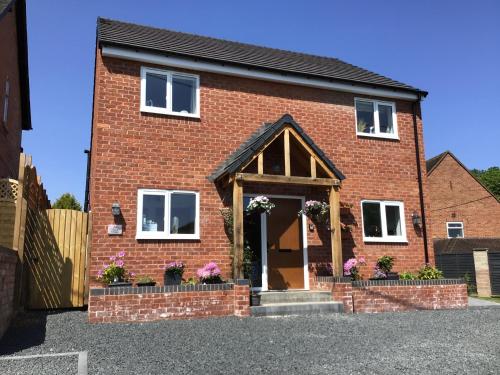 Luxurious 3 bedroom house Shangri la in village of Alfrick with free off road parking for 3 cars in an area of outstanding natural beauty, superb walking,close to Worcester, Malvern showground, theatre, Malvern hills, dogs welcome