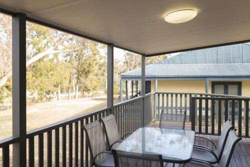 a patio area with a patio table and chairs, Alivio Tourist Park Canberra in Canberra