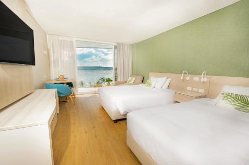Two beds facing a TV in a room in a San Andres hotel