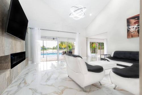 ห้องส่วนกลางสำหรับนั่งเล่น/ดูทีวี, Modern Lakefront Home in เวลลิงตัน (FL)