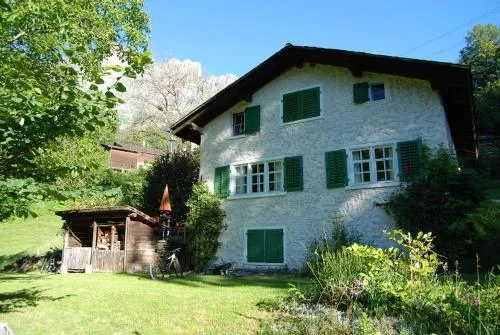 Bergbauernhaus an Wasserfall und Waldrand in Schwändi, Schweiz
