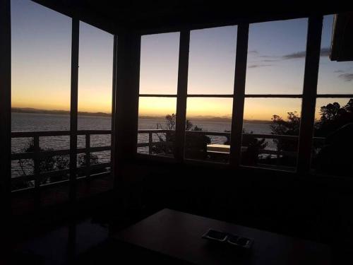 Beachfront bach w beautiful sunsets, pizza oven, handy to town in Tamaterau