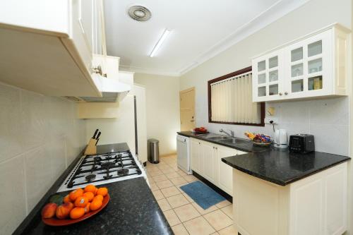 Kitchen, 3BR Home with Pool Near Shops, M5 & Train Stations in Marrickville