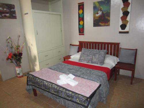 a bedroom with a bed and a dresser, Lyn's Do Drop Inn in Baguio