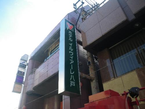 a street sign on a pole in front of a building, Hotel IL VIALE Hachinohe in Hachinohe