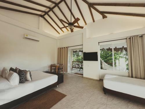 Room with beds, TV, and high ceilings at one of the best Barú hotels.