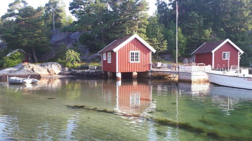 Large house with sea arch, beach and jetty in Høvåg