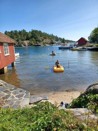 Large house with sea arch, beach and jetty in Høvåg