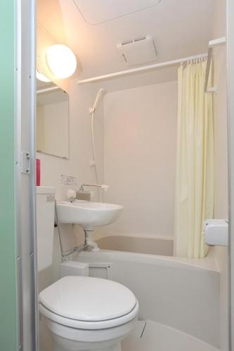 a white toilet sitting next to a bath tub in a bathroom, BJ Family Inn in Kyoto