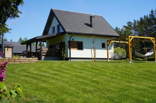 Domek z kominkiem nad jeziorem z jacuzzi ogrodowym