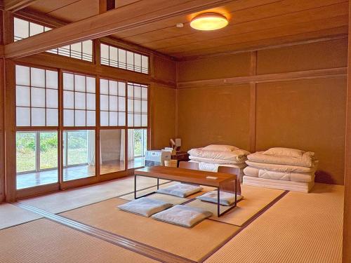 広い縁側とタタミの部屋に天井吹抜けのオープンキッチンがある一軒家でキッチンやバスルームは最新設備