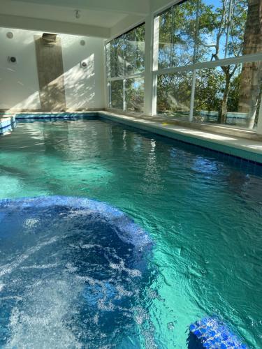 泳池, Villa Sambaqui com piscina coberta privativa, vista e acesso ao mar in 普拉亞德丹妮拉