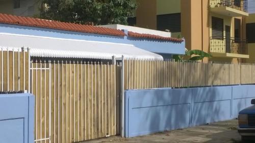 a white fence with a blue and white door, Calle Hollanda 3 Bedroom Home in San Juan