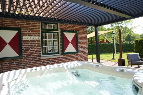  De Brittenburg 4-persoons, finse sauna, hottub, sunshower, grote zonnige omheinde tuin, wifi en huisdier vriendelijk in Lievelde