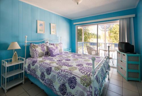 a bedroom with a blue bed and blue walls, Captiva Island Inn in Captiva Island (FL)