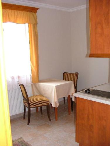 a kitchen with a table, chairs and a refrigerator, Bruckner Villa Apartman in Balatonfured