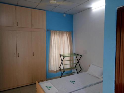 a bedroom with a bed and a chair, International Youth Hostel Mysuru in Mysore