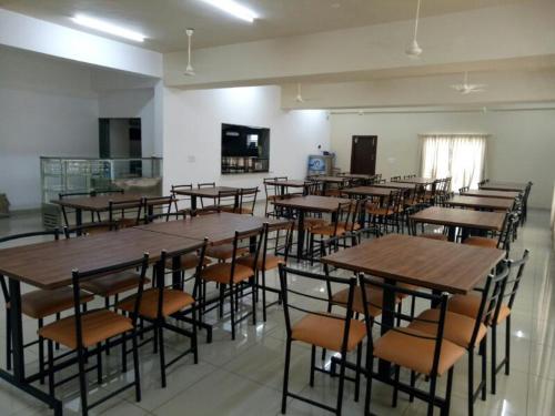 a room filled with lots of tables and chairs, International Youth Hostel Mysuru in Mysore