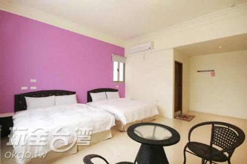 a bedroom with a bed, chair, table and a lamp, CHONG Kam Bed and Breakfast in Penghu