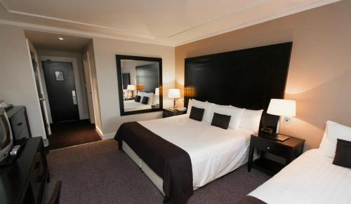 a hotel room with two beds and a television, Shamrock Lodge Hotel in Athlone