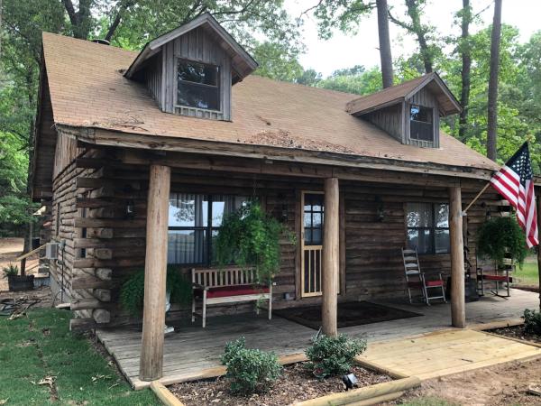 A la foto es mostra l'objecte Cora's Main Log Cabin situat a la ciutat de Tyler.