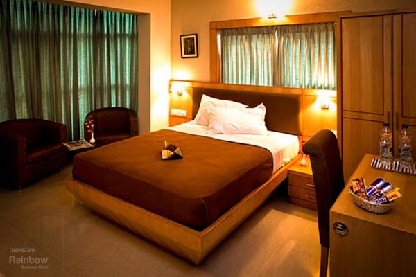 The photo shows the New Rainbow Business Hotel located in the city of Bengaluru.
