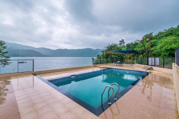 På billedet ses objektet SaffronStays Riverdale - 4BR pool villa in Lavasa with gazebo, Indonesian artwork, and cricket pitch beliggende i byen Dasave.