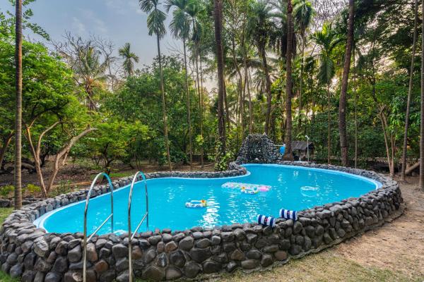 På bildet vises objektet SaffronStays Chikoo Wadi- 3BDR Pet-friendly Villa with Pool in Boisar som ligger i byen Chinchani.