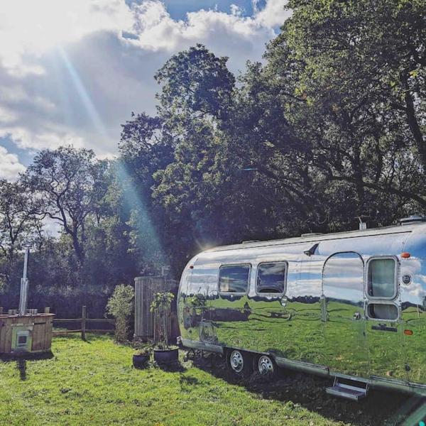 A la foto es mostra l'objecte Airstream, vintage American caravan & Hottub situat a la ciutat de Bickington.