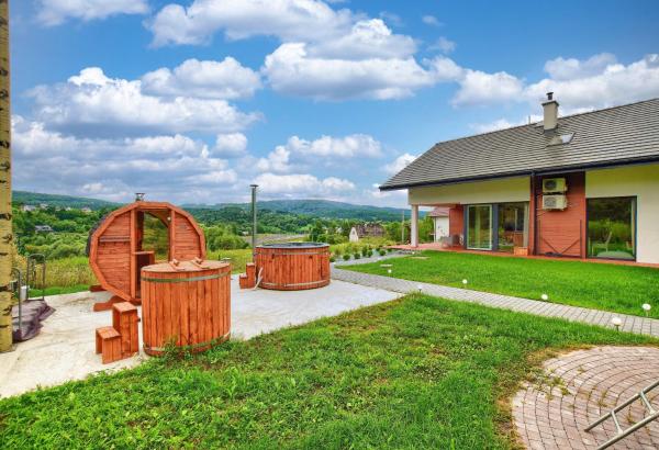 Na fotografii je vidět objekt ArPioNa dom nad jeziorem z jacuzzi, sauną i placem zabaw nacházející se ve městě Dąbrówka.